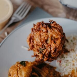 Close-up view of a delicious onion bhaji with rice on a plate, showcasing vibrant Indian cuisine.
