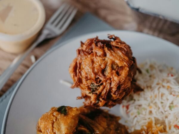 Close-up view of a delicious onion bhaji with rice on a plate, showcasing vibrant Indian cuisine.